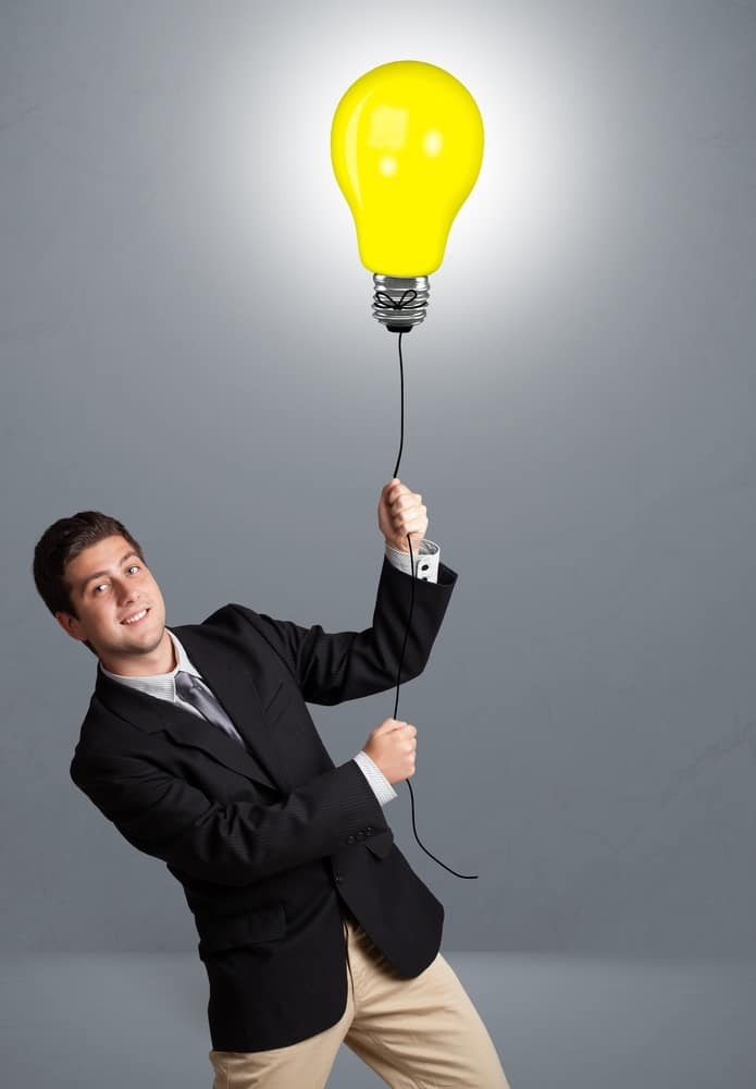 Handsome man holding light bulb balloon