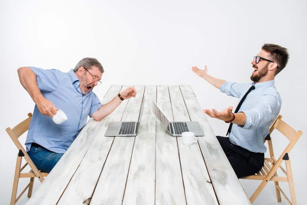 The two colleagues working together at office on white background